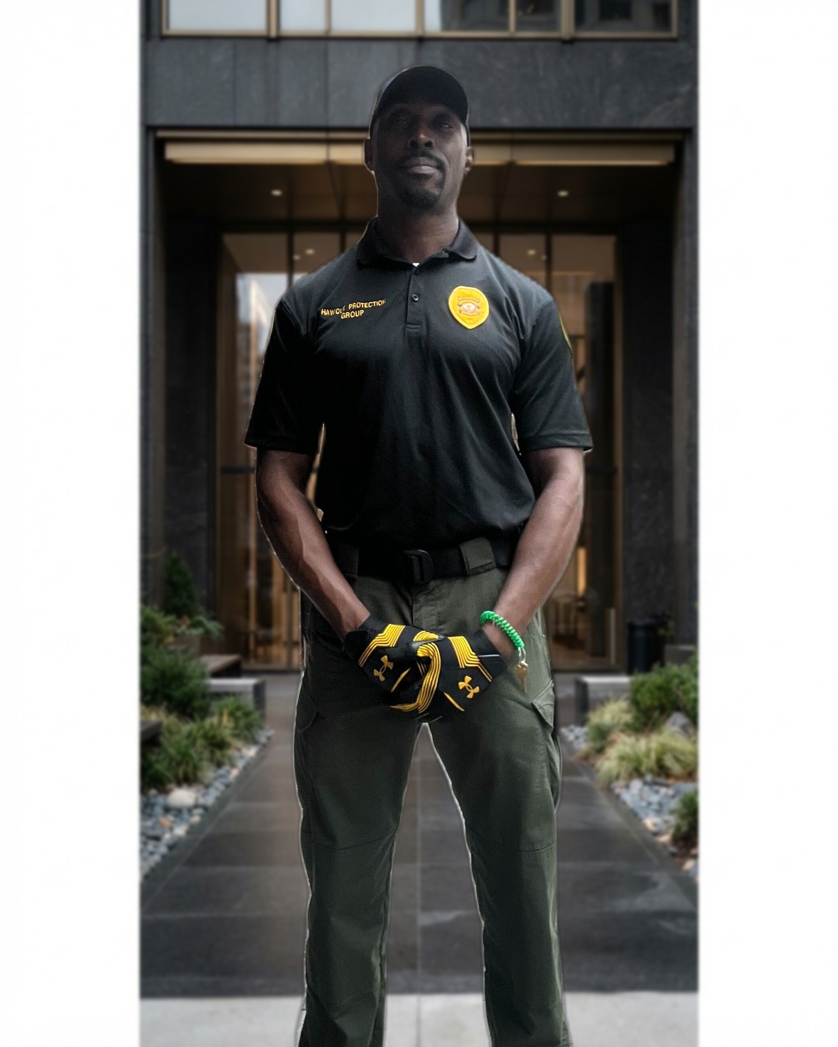 Hawque Protection Group security officer in a black branded uniform at a premium commercial venue entrance
